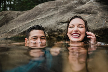 Portrait playful young couple swimming in lake