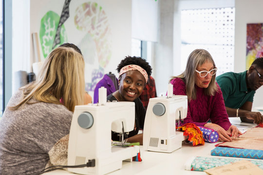 Female fashion designers working at sewing machines in studio