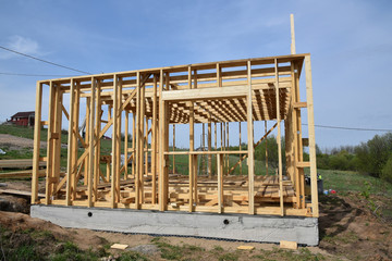 Construction home framing against blue sky.Wood frame residential building under construction.Building construction,wood framing structure at new property development site. mortgage, loan.