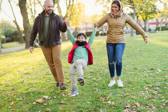 Playful Muslim family in autumn park