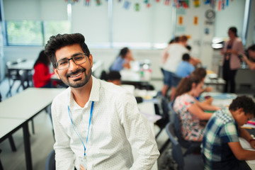 Portrait smiling, confident male teacher in classroom