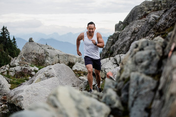 Male hiker running over rocks, Dog Mountain, BC, Canada