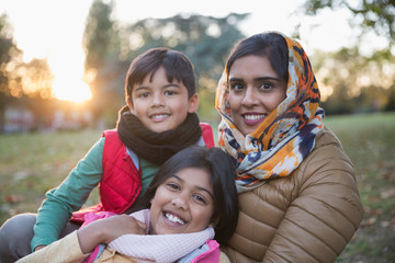 Portrait happy Muslim mother in hijab with children in autumn park