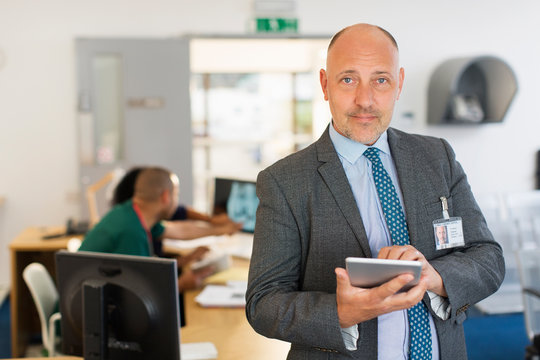 Portrait Confident Male Administrator With Digital Tablet In Clinic