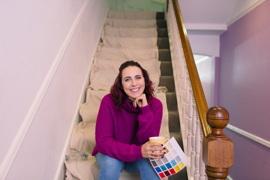 Portrait Confident Woman Redecorating, Holding Paint Swatch On Stairs