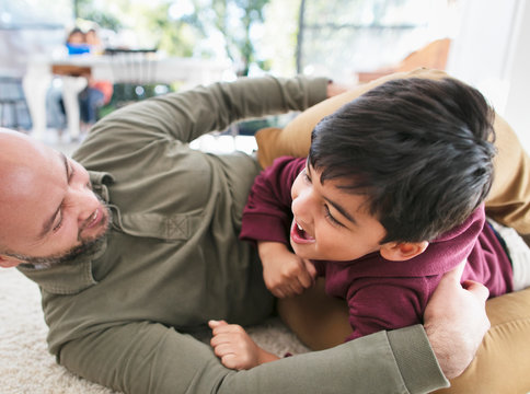 Playful father and son on floor