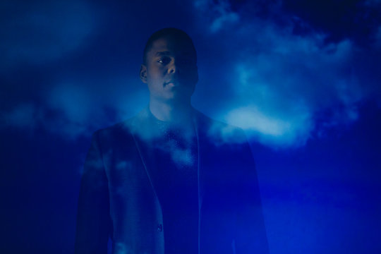 Double exposure thoughtful businessman against blue sky with clouds