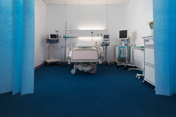 Vacant hospital room with bed and medical equipment