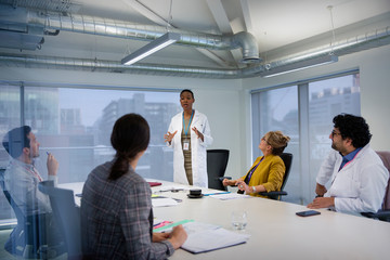 Female doctor leading conference room meeting