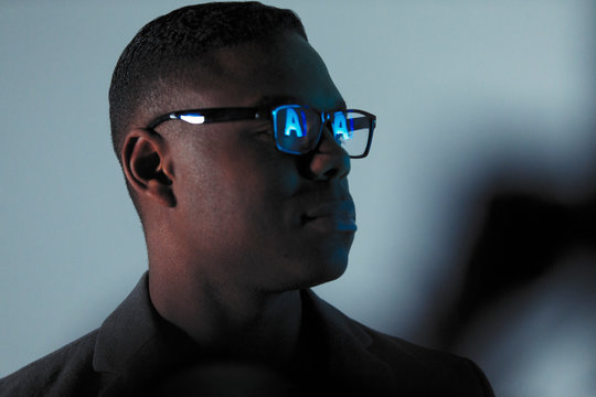 Double exposure businessman with reflection of AI text in eyeglasses