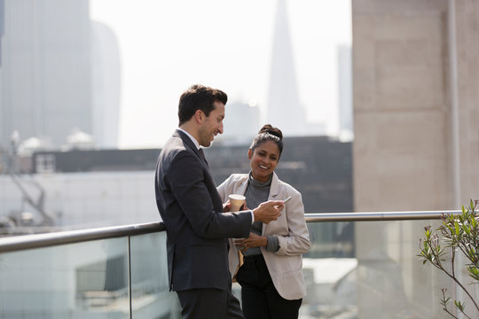 Business people talking on sunny, urban balcony