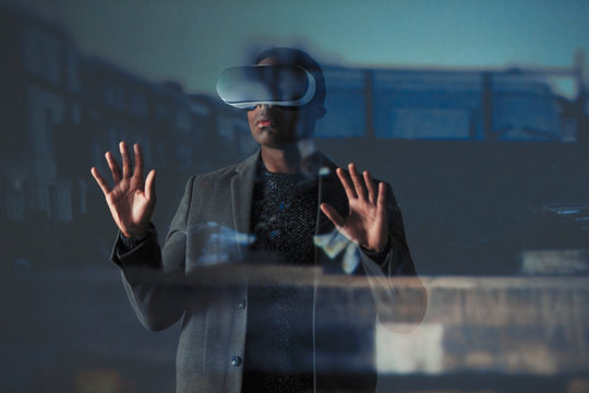 Double exposure businessman using virtual reality simulator glasses 