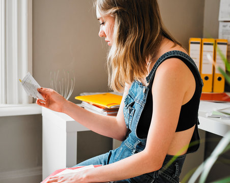 Young female college student studying with flash cards