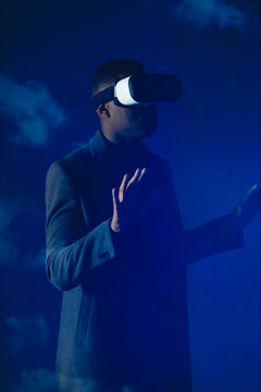 Double exposure businessman with virtual reality simulator glasses against blue sky