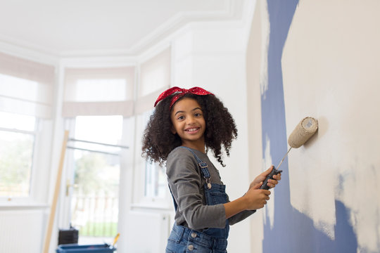 Portrait happy girl painting wall
