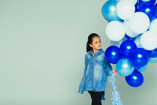 Smiling girl with blue and white balloon bunch