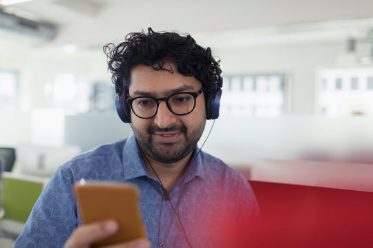Businessman listening to music with headphones and mp3 player