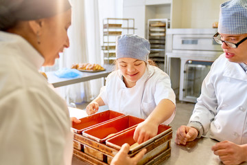 Chef and students with Down Syndrome baking bread in kitchen