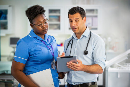 Male doctor with digital tablet talking with female nurse in hospital