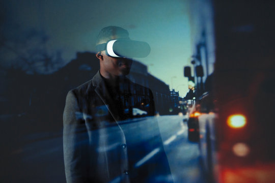 Double exposure businessman with virtual reality simulator glasses against city street 