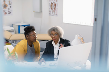 Female doctor meeting with patient at computer in doctors office