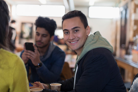 Portrait confident young man hanging out with friends in cafe