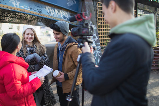 Young adults vlogging under urban bridge