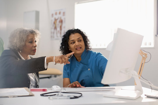 Female doctor and patient using computer in doctors office