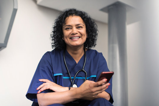 Portrait confident female doctor using smart phone