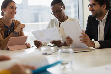Business people discussing paperwork in conference room meeting