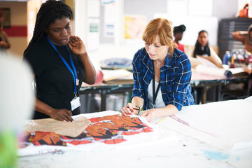 Female artists looking at screen print in art studio