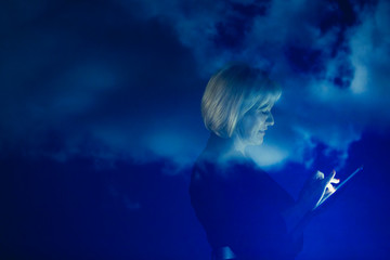 Double exposure businesswoman with digital tablet against blue sky with clouds