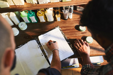 Male barbershop owner checking product inventory