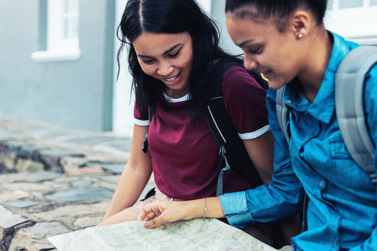Young female backpackers looking at map