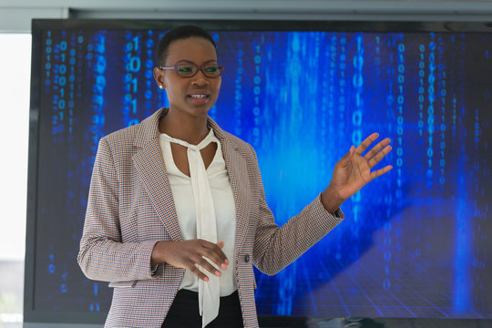 Businesswoman leading meeting at television screen