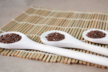 Flax seeds on three wooden spoons on the table