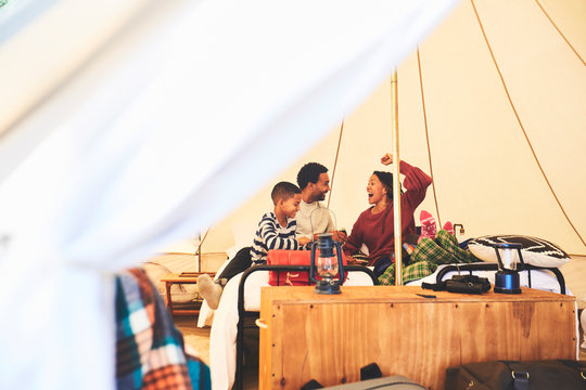Happy family relaxing in camping yurt - Powered by Adobe