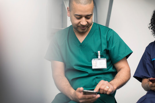Male surgeon using smart phone