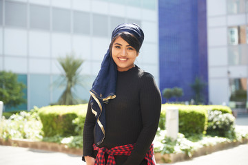 Portrait confident young woman wearing headscarf in sunny park