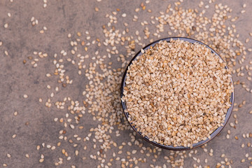 Sesame seeds on a brown textured background, healthy food