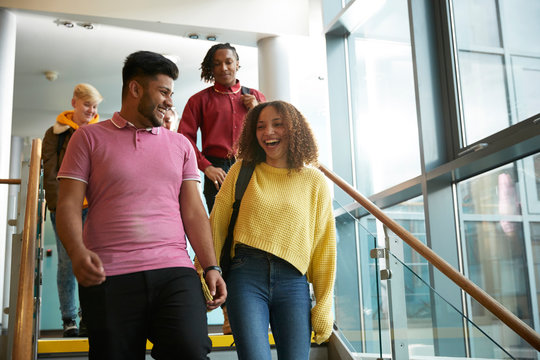 Happy college students descending stairs