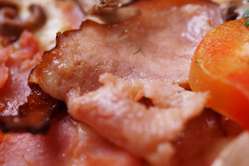 Close up of fresh baked pizza with prosciutto and bacon