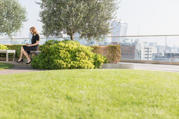 Businesswoman working on urban rooftop garden
