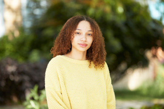Portrait confident young woman in yellow sweater
