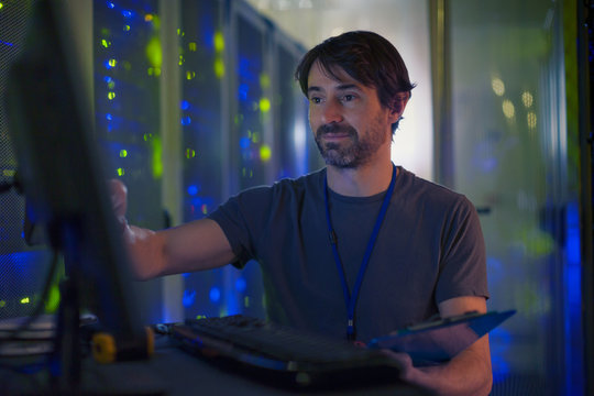 Server room technician working at computer