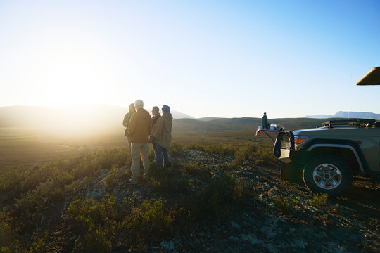 Safari tour group enjoying idyllic sunrise from hill South Africa