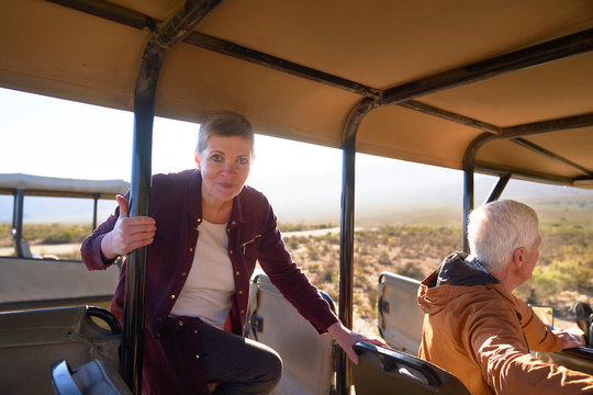 Portrait confident mature woman getting into safari off-road vehicle