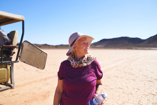 Happy senior woman on safari in sunny arid desert South Africa