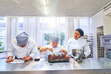 Chef and students with Down Syndrome baking muffins in kitchen