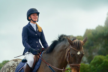 Confident smiling teenage girl equestrian horseback riding